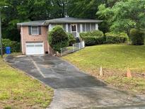 Charming single-Gathering home featuring a one car garage, brick facade, and a well-manicured lawn at 1829 Detroit Ave, Atlanta, GA 30314