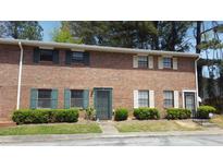 Brick two-story townhome with green and white shutters and a well-maintained lawn with trimmed bushes at 6354 Shannon Pkwy # 13C, Union City, GA 30291