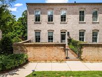 Charming brick townhouse featuring a gated entrance, multiple windows, and well-maintained landscaping at 3481 Landen Pine Ne Ct, Atlanta, GA 30305