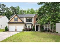 Charming two-story home with a well-manicured lawn, two-car garage, and tasteful landscaping at 6378 Grey Fox Way, Riverdale, GA 30296