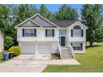 Charming two-story home featuring a two-car garage and a welcoming front entrance with a staircase at 115 Manx Dr, Grantville, GA 30220