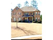 Charming two-story brick home featuring a well-manicured lawn and welcoming entrance at 305 Rugged Dr, Stockbridge, GA 30281