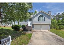 Charming two-story home with a two-car garage and well-manicured lawn at 4115 Kensington Cv, Atlanta, GA 30349