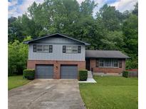 Charming split-level home with a two-car garage and a well-maintained front yard at 4274 Carrollwood Dr, Stone Mountain, GA 30083