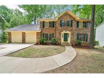 Charming brick two-story home with a two-car garage and a well-manicured lawn at 5141 Rocky Run, Stone Mountain, GA 30088
