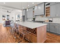 Bright, open kitchen with a large island, gray cabinets, stainless appliances, and hardwood floors at 2018 Presley Ne Way, Atlanta, GA 30317
