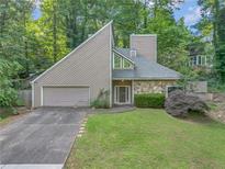 Inviting contemporary home with stone accents, lush landscaping, and a two-car garage nestled in a wooded setting at 260 Lamplighter Se Ln, Marietta, GA 30067