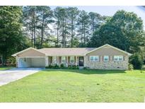 Charming brick ranch-style home with an attached carport and a well-maintained front lawn at 2628 Hickory Trl, Snellville, GA 30078