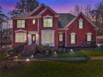 Stately brick home with manicured lawn, landscape lighting, and elegant architectural details at 4213 Bretdale Nw Run, Kennesaw, GA 30152