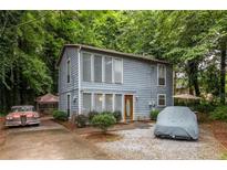 Charming two-story home with blue siding and a well-maintained yard surrounded by lush trees providing lots of shade at 5006 Dantel Way, Stone Mountain, GA 30083