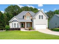 Charming two-story home featuring stone accents, a well-manicured lawn, and an attached two-car garage at 59 Creekside Blf, Hiram, GA 30141