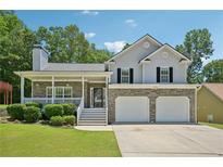 Charming two-story home featuring a covered porch, stone accents, and an attached two-car garage at 3705 Tate Pl, Austell, GA 30106