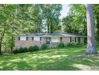 Charming single-story brick home nestled among mature trees and a lush, green lawn at 4236 Beaver Ruin Nw Ct, Lilburn, GA 30047
