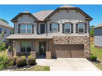 Charming two-story home featuring stone accents, a covered porch, and a two-car garage at 4255 Sunflower Cir, Cumming, GA 30040