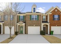 Charming brick townhome featuring a one-car garage and well-maintained landscaping at 1332 Adcox Sq, Stone Mountain, GA 30088