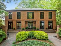 Stately brick home with lush landscaping, black framed windows and doors, and inviting curb appeal at 4411 Paces Battle Nw, Atlanta, GA 30327