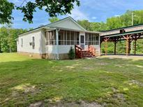 Cozy home with a screened-in porch and a spacious covered parking area surrounded by lush greenery at 505 Sandhill Hickory Level Rd, Carrollton, GA 30116
