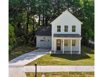 Charming two-story home with a well-manicured lawn and a paved driveway leading to an attached garage at 1888 Goddard Se St, Atlanta, GA 30315