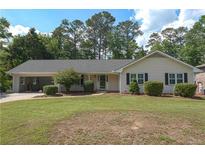 Charming single-story home with a well-manicured lawn and attached garage in a peaceful, wooded neighborhood at 4137 Wellington Hills Ln, Snellville, GA 30039