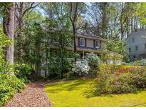 Charming two-story home with a well-manicured lawn and mature trees providing privacy at 6795 Brandon Mill Rd, Atlanta, GA 30328