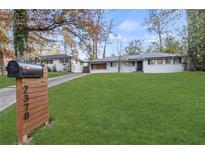 Charming ranch-style home with freshly painted exterior and expansive green lawn and an adjacent house sharing the driveway at 2378 Green Forrest Dr, Decatur, GA 30032