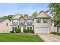 Two-story home featuring a stone facade, well-manicured lawn, and an attached two-car garage, on a sunny day at 2896 Chilhowee Dr, Atlanta, GA 30331