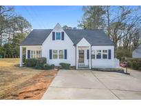 Charming cottage-style home featuring a well-maintained lawn and blue shutters at 1831 Dresden Dr, Brookhaven, GA 30319