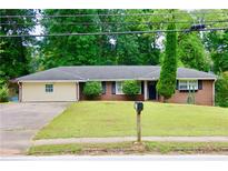 Charming brick ranch home with a well-maintained front lawn and mature trees at 3967 Norman Rd, Stone Mountain, GA 30083
