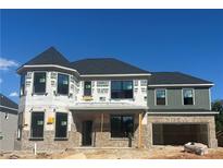 Charming two-story home with brick facade, gray accents, and a turret feature under a clear blue sky at 4377 Hosch Reserve Dr, Buford, GA 30519