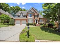 Charming brick two-story home with a well-manicured lawn, two-car garage and a classic architectural style at 580 Washington Way, Cumming, GA 30040