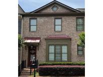 Charming brick townhouse with unique architectural details and well-maintained landscaping at 10765 Arlington Pt, Alpharetta, GA 30022