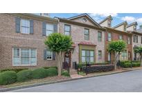 Charming brick townhome with a well-manicured front yard and inviting entrance at 10765 Arlington Pt, Alpharetta, GA 30022