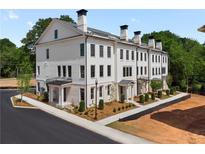 Stunning exterior view of townhome with balconies, brick facade, and professionally landscaped grounds at 415 Mayfair Ct, Alpharetta, GA 30009