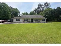 Charming single-story home with a large front lawn and inviting front porch at 4284 Village Green W Cir, Conyers, GA 30013