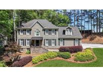 Charming two-story home featuring a landscaped front yard with vibrant shrubs and a stone facade entrance at 4320 Oklahoma Nw Way, Kennesaw, GA 30152