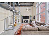 Bright living room featuring a spiral staircase, high ceilings, large windows, and a comfortable sofa at 572 Edgewood Se Ave # 303, Atlanta, GA 30312