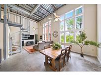 Open-concept living space features a spiral staircase, large windows, a ceiling fan, and concrete flooring at 572 Edgewood Se Ave # 303, Atlanta, GA 30312
