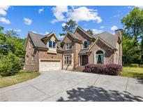 Beautiful brick home with a well-manicured lawn and a spacious driveway, featuring a two-car garage and a welcoming entrance at 1614 Rucker Rd, Alpharetta, GA 30009