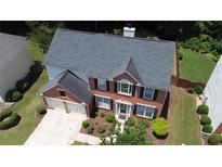 Aerial view of a red brick home with a well-manicured lawn and a two-car garage at 4321 Sugar Maple Chase Nw, Acworth, GA 30101