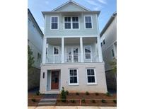 Charming, two-story home featuring a welcoming front porch and light blue siding at 115 Pinecone Pkwy, Alpharetta, GA 30022