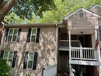 Two-story townhome featuring black shuttered windows and a covered entrance way at 386 Teal Ct, Roswell, GA 30076