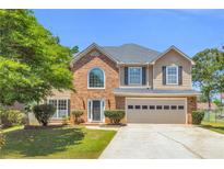 Charming two-story home features a well-maintained lawn and attached two-car garage at 3327 James Harbor Way, Lawrenceville, GA 30044