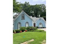 Charming single-Gathering home with a well-manicured lawn, complemented by flowering shrubbery and a striking blue facade at 3740 Ashford Ne Pt, Brookhaven, GA 30319