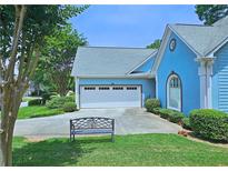 Charming blue home with a well-manicured lawn, a two-car garage, and a quaint front bench at 3740 Ashford Ne Pt, Brookhaven, GA 30319