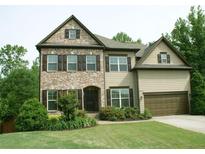 Charming two-story home with a brick facade and a well-manicured lawn at 4020 Alligator Pt, Cumming, GA 30028