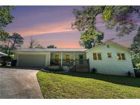 Charming single-story home featuring a covered front porch, brick siding, and a well-maintained lawn at 4384 Herschel Rd, College Park, GA 30337