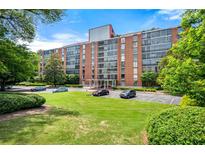 A charming brick apartment building with mature trees and green lawn, providing a tranquil setting at 130 26Th Nw St # 801, Atlanta, GA 30309