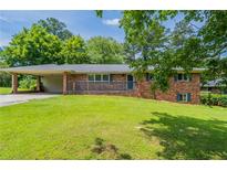 Charming one-story brick home with a carport and large front yard at 29 Parkwood Ne Dr, Kennesaw, GA 30144