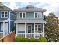 Charming two-story home featuring a welcoming front porch and light-green siding and trimmed with white at 630 John Wesley Dobbs Ne Ave, Atlanta, GA 30312