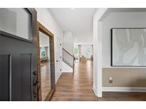 Inviting foyer with wood floors, stairs, and a view into the open-concept living spaces at 707 Mirror Lake Parkway Way, Villa Rica, GA 30180